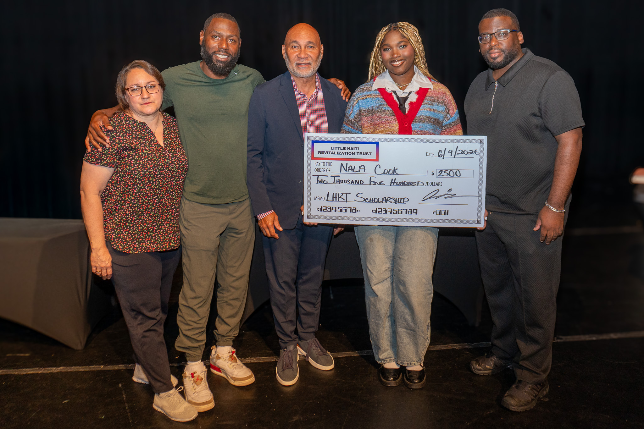 Five people hold a check