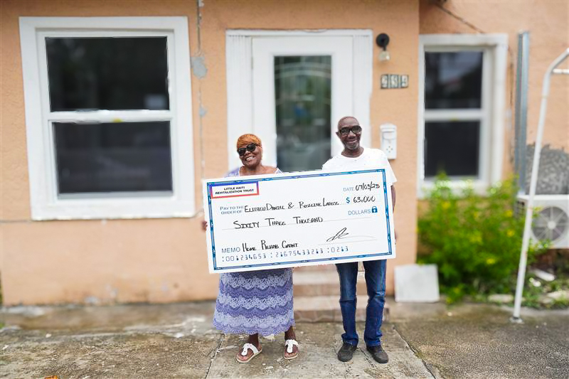 Two people holding a check